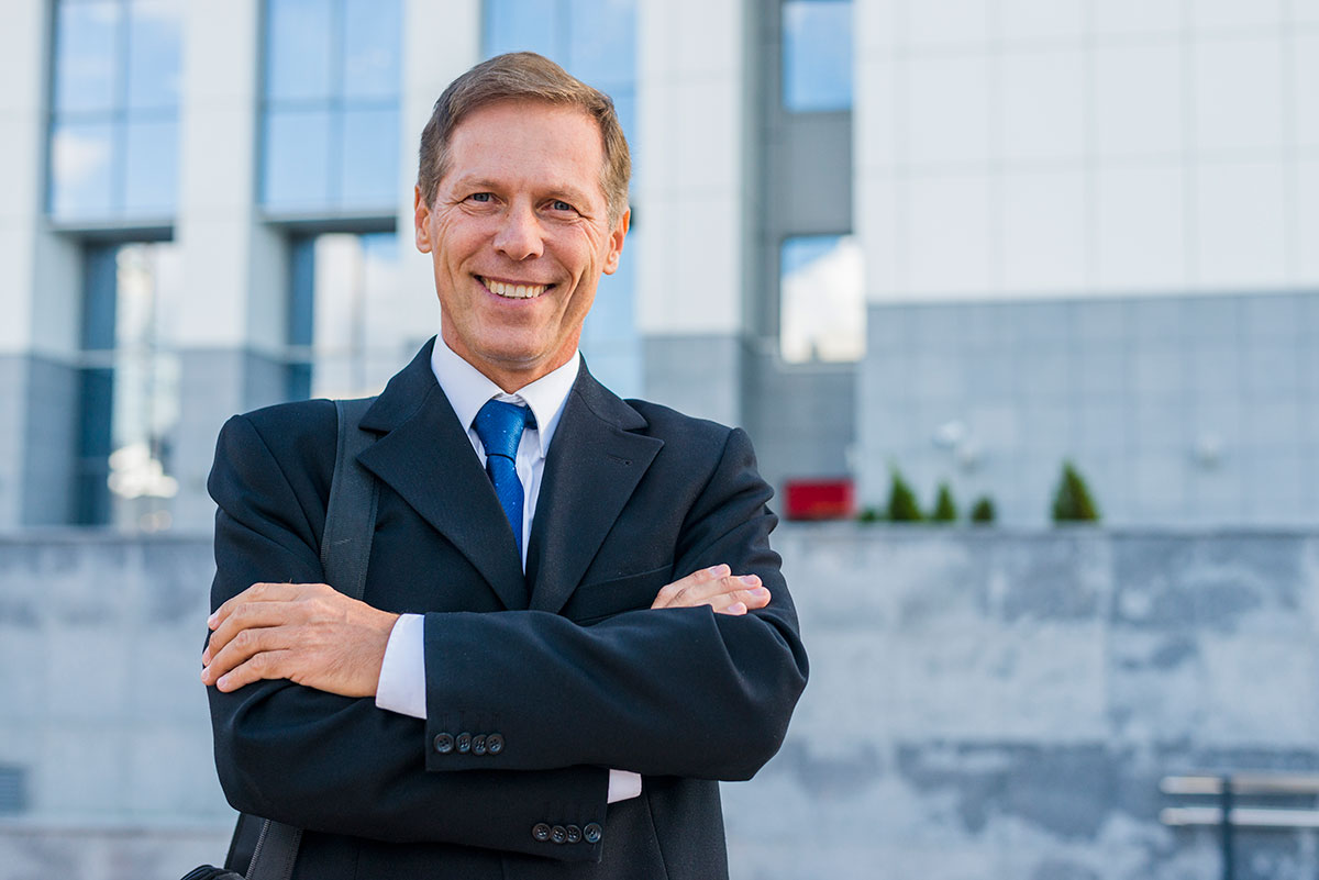 portrait happy mature businessman with folded arms